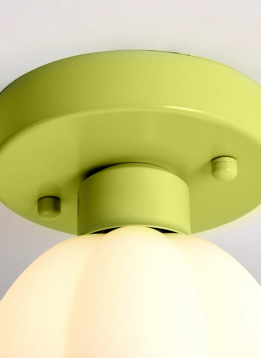 Close view of the green metal canopy and the top of the white glass shade