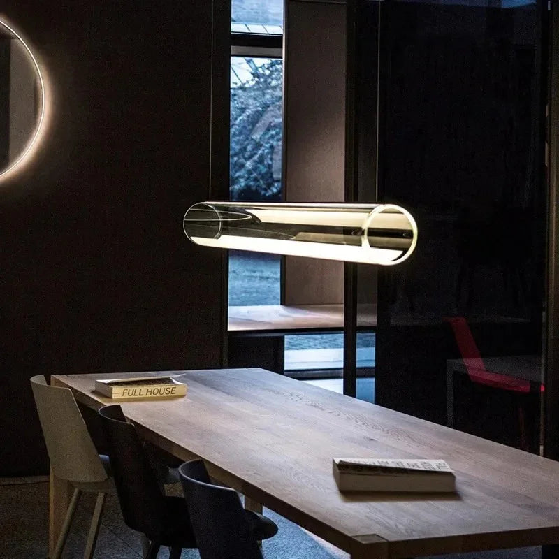 The tube above a wooden dining table in a dark room with a window