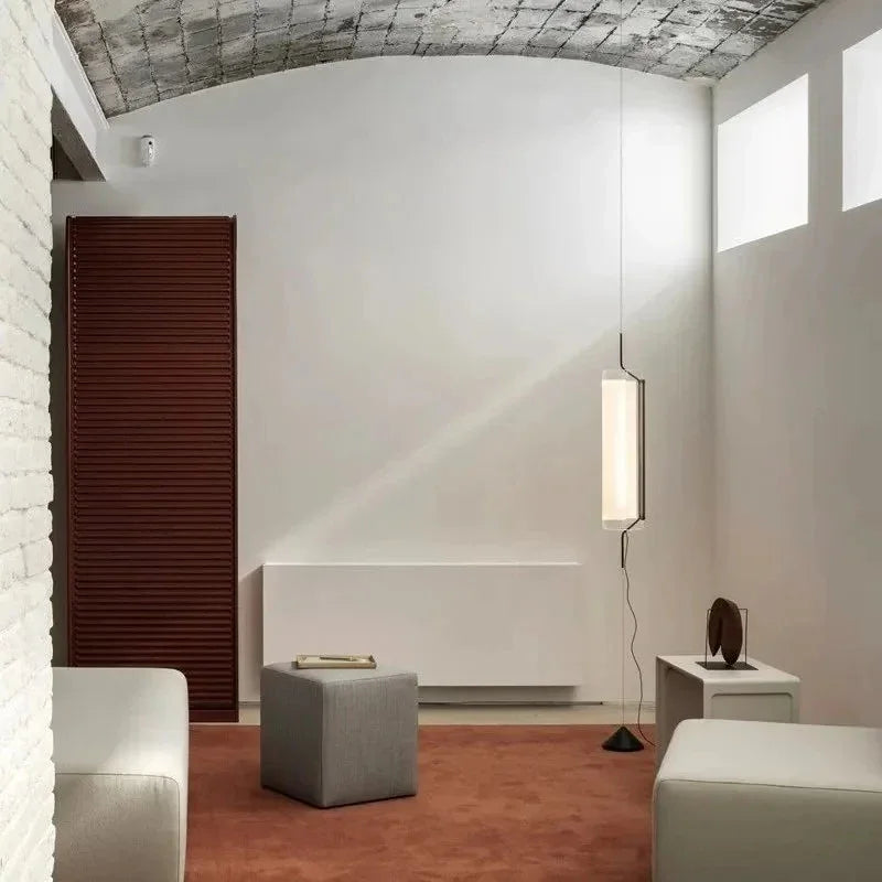The tube lit in a vaulted white room above a low bench and a stool