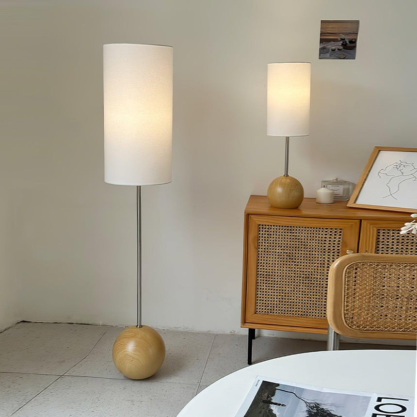 Globe table lamp on a sideboard beside a matching tall floor version
