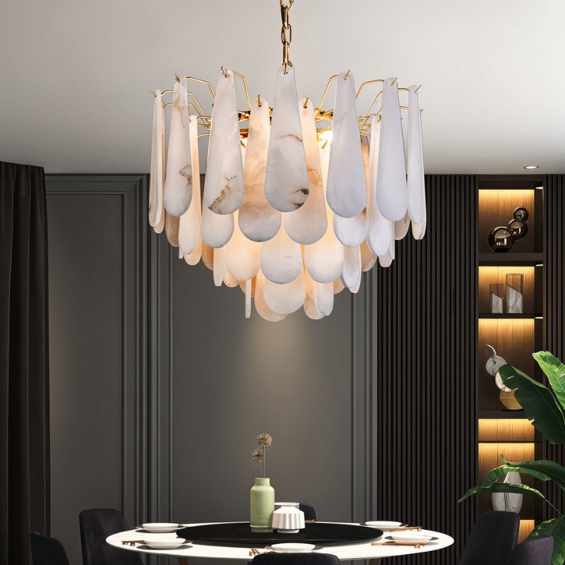 The lit chandelier above a round table with lit shelves and a plant behind