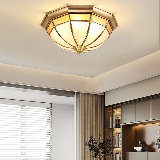 Faceted brass dome ceiling light seen from below in a bedroom