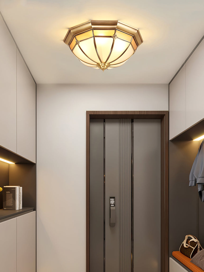 Faceted brass dome ceiling light near a doorway in a corridor