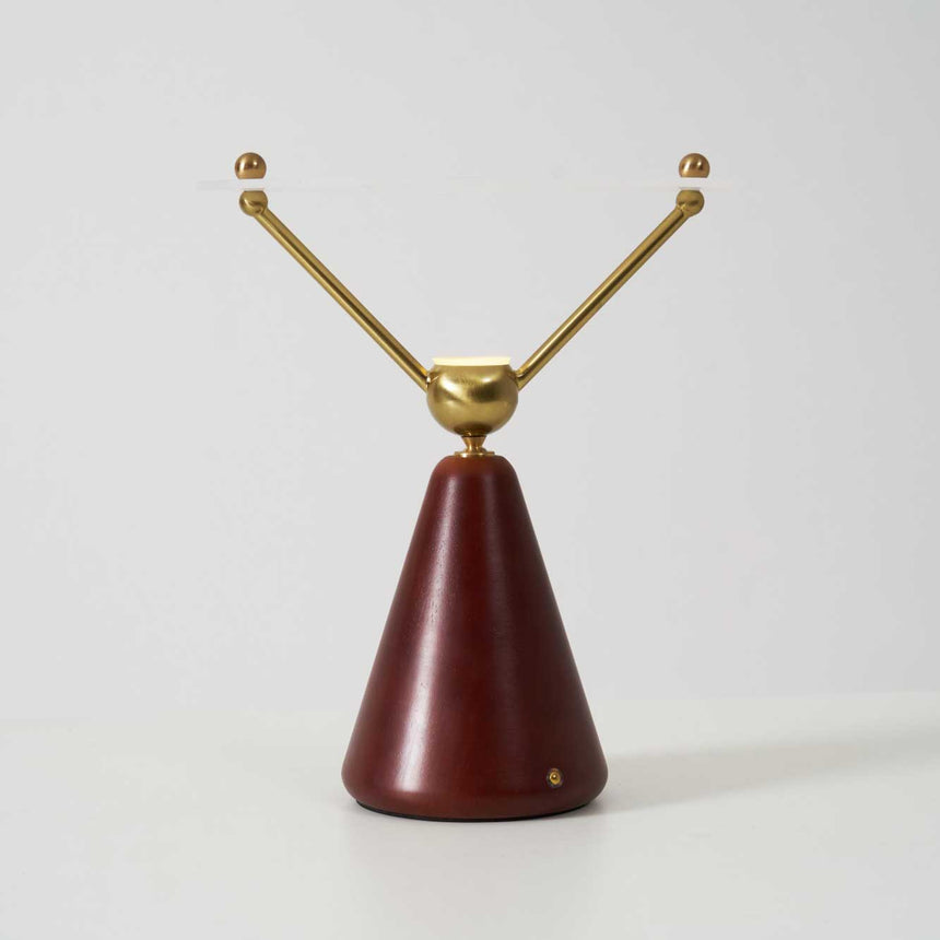 The two brass arms of the lamp seen from the front, plain ground