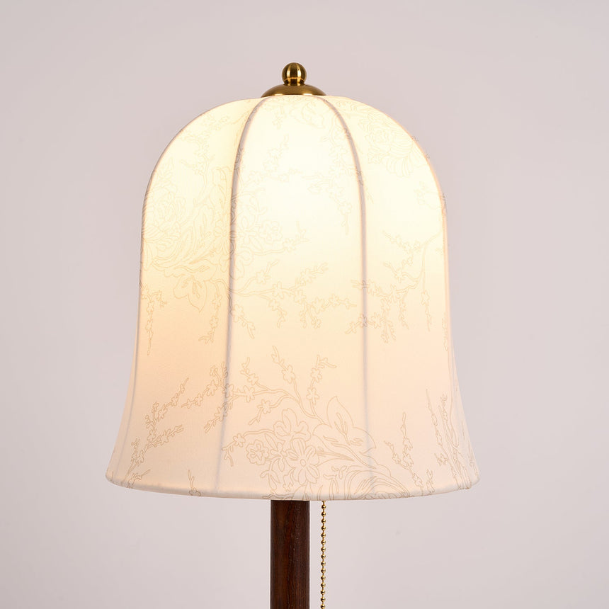 Close view of the lit bell shade and the pull chain under it