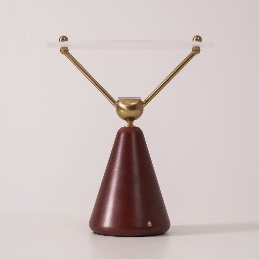 Gold and white table lamp seen in full against a plain ground