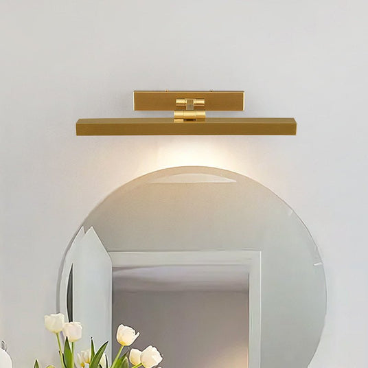 Gold bar lit above a round mirror over a basin with white tulips