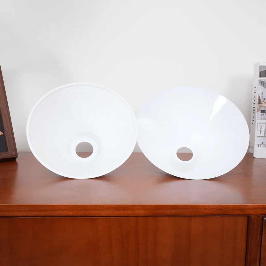 The two white cone shades shown side by side on a wood cabinet
