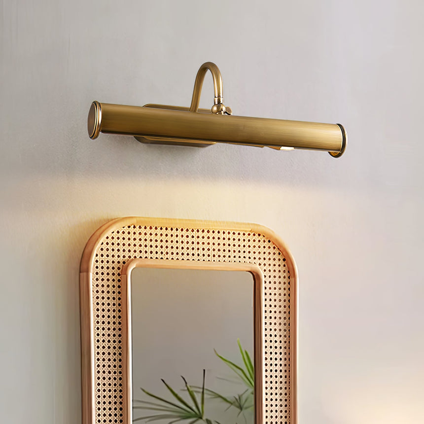 Copper tube lit close above a rattan framed mirror on a plaster wall