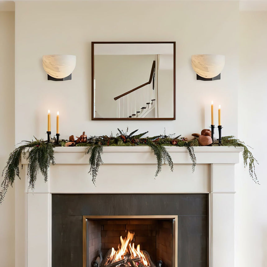A pair lit above a lit fireplace with candles and garland on the mantel
