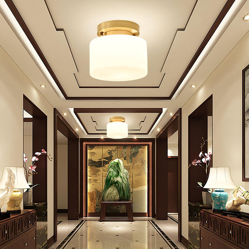 Brass and white glass ceiling lights along a corridor with a coffered ceiling