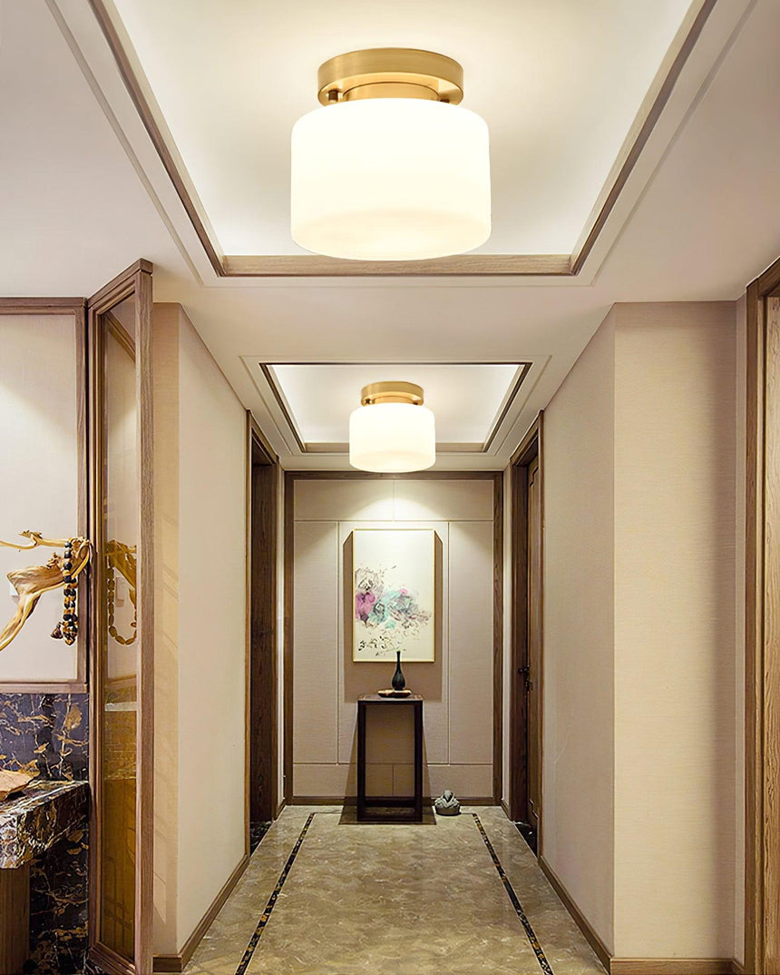 Brass and white glass ceiling lights in a corridor with a stepped ceiling