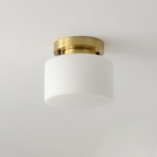 Brass and white glass ceiling light seen close against a plain ceiling