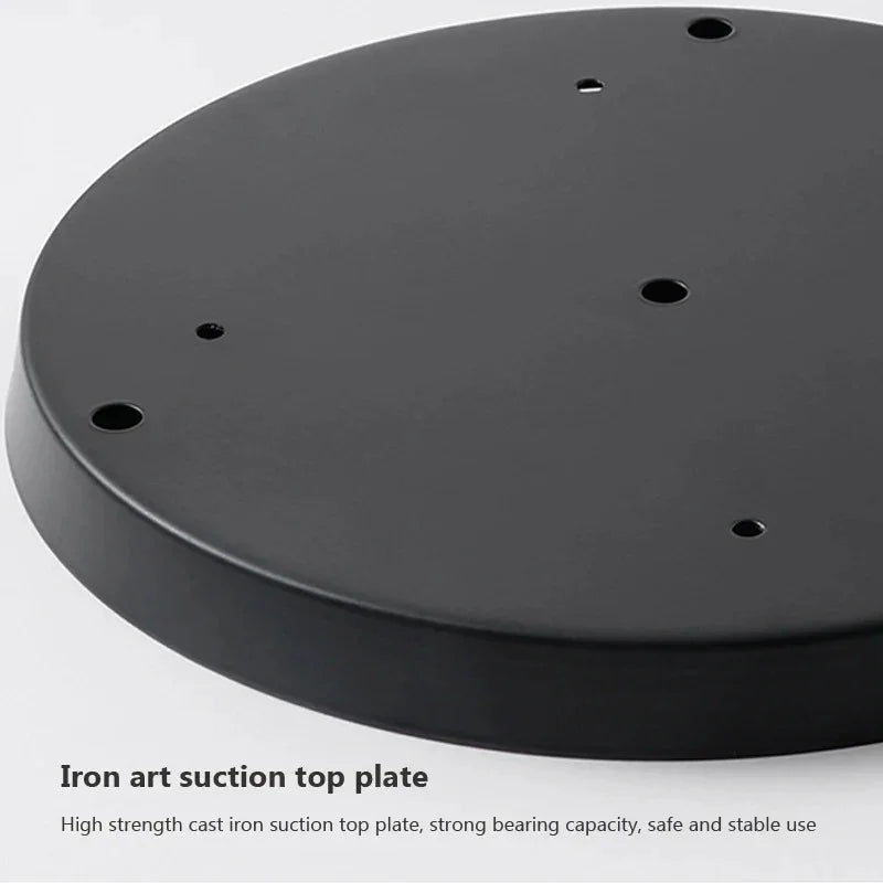 The black cast iron ceiling plate shown face down on a pale background
