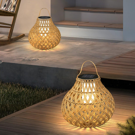 Two lanterns lit on a timber deck beside a doorway and a garden step