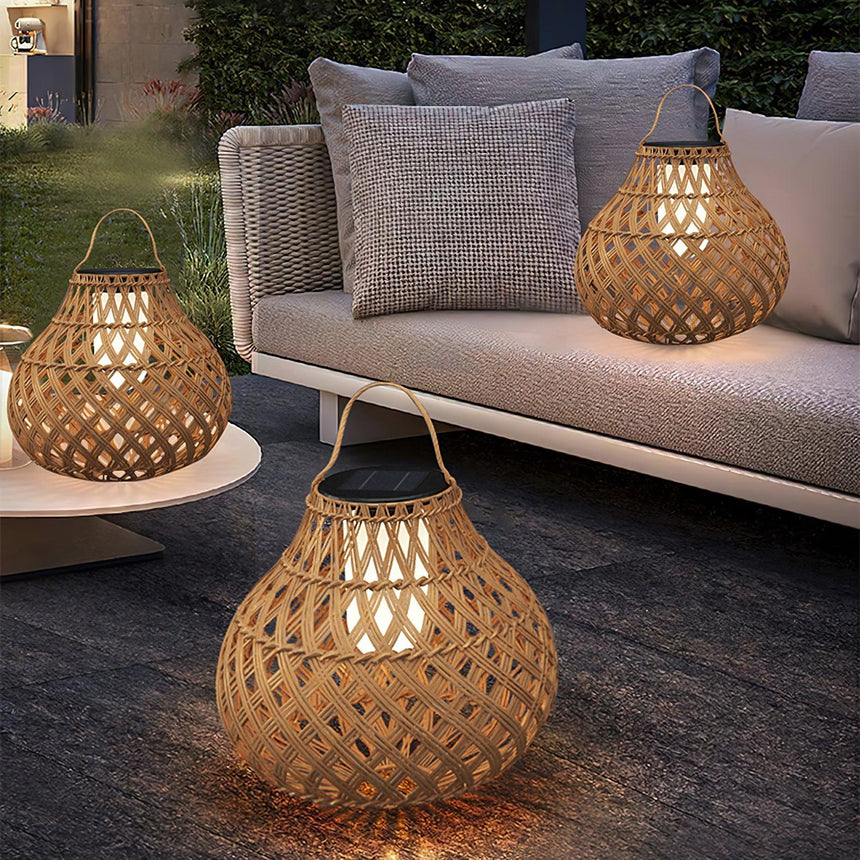 The lantern lit on a low table beside a garden sofa with cushions