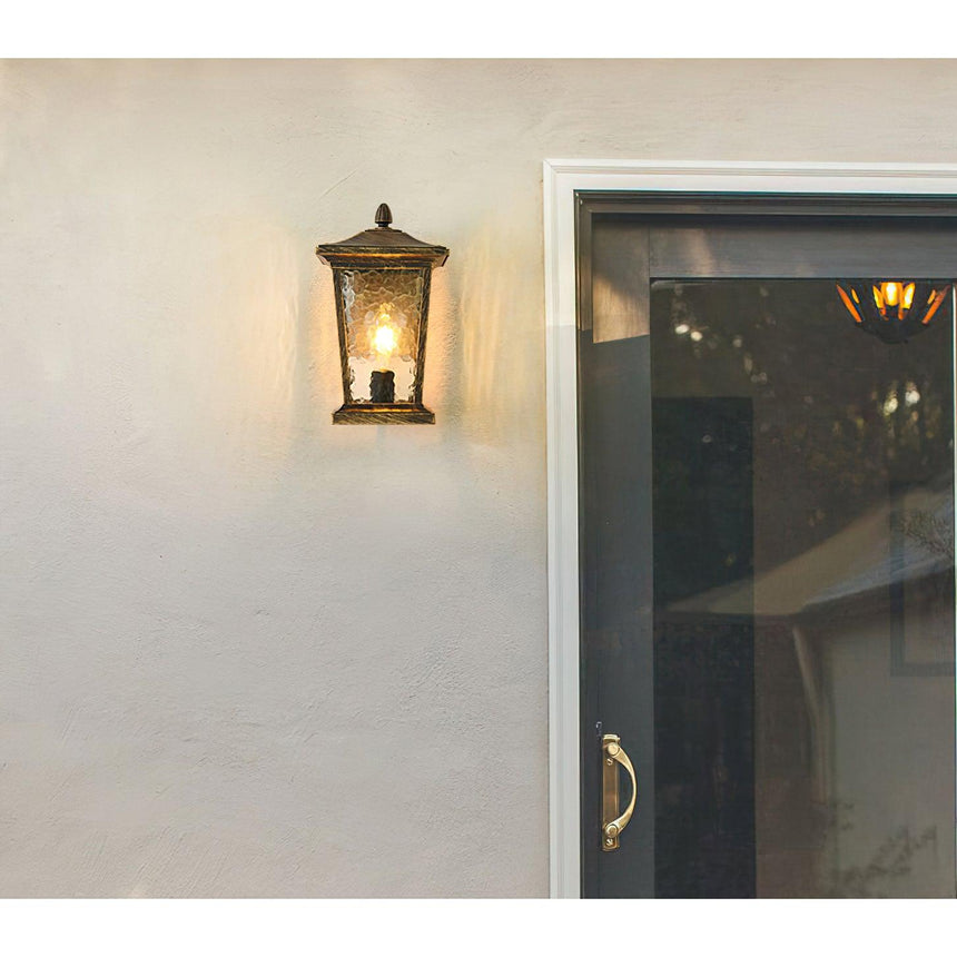 The lantern on a pale wall beside a glass door with a brass handle