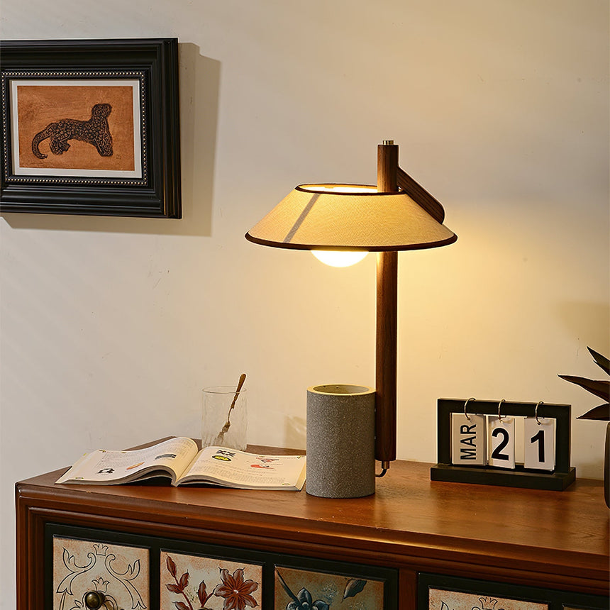 Cement base lamp lit on a painted cabinet beside an open magazine