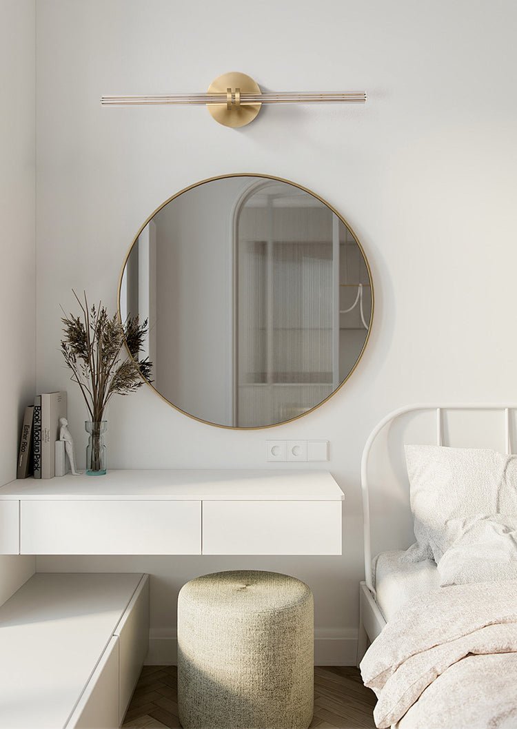 Rod lit on a bedroom wall above a round mirror, a console and a stool