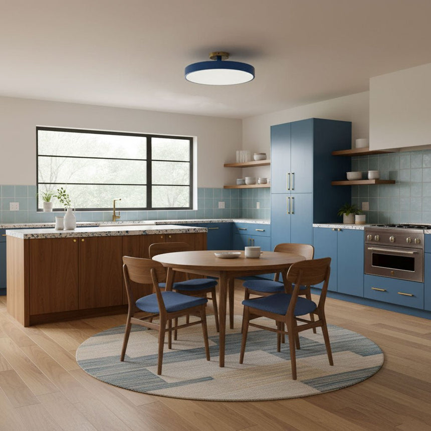 Blue drum ceiling light above a round dining table in a blue kitchen