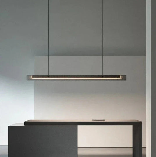 The lit bar hung above a kitchen counter beside tall cabinets
