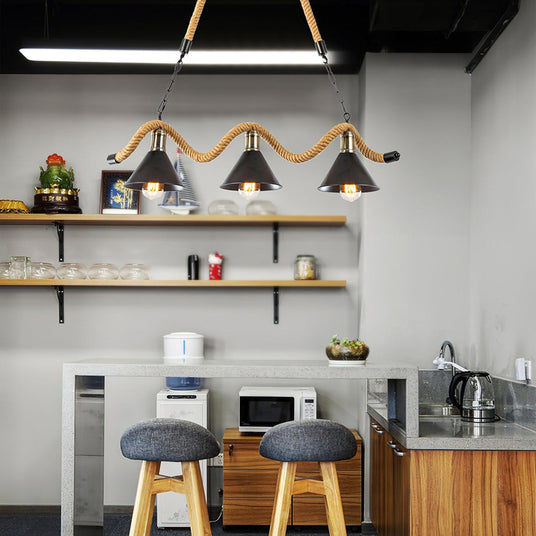 Chandelier lit above a kitchen counter with two stools and open shelves