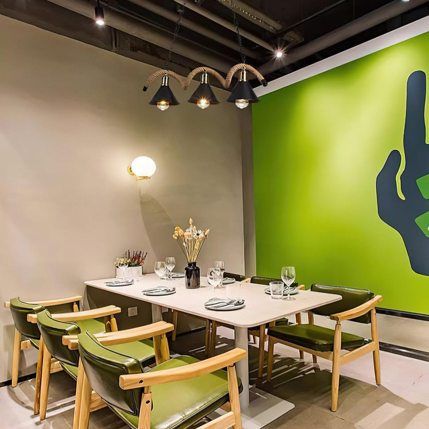 The wave lit above a dining table with green chairs around it