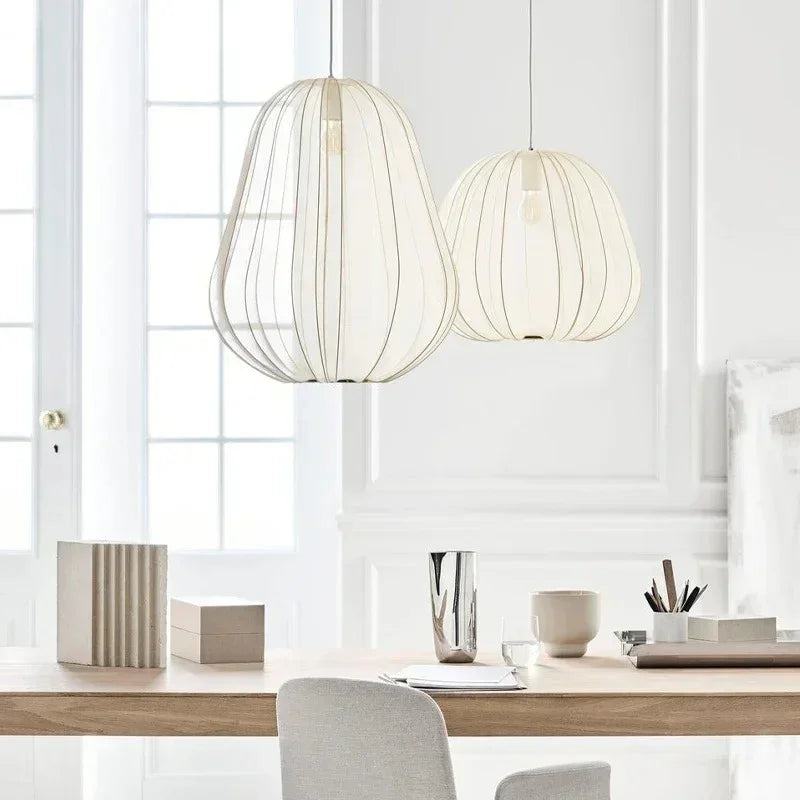 Two ivory fabric lanterns above a kitchen counter with white cabinets
