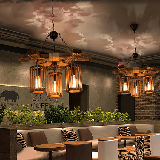 Two of the chandeliers lit above round cafe tables and a bench seat