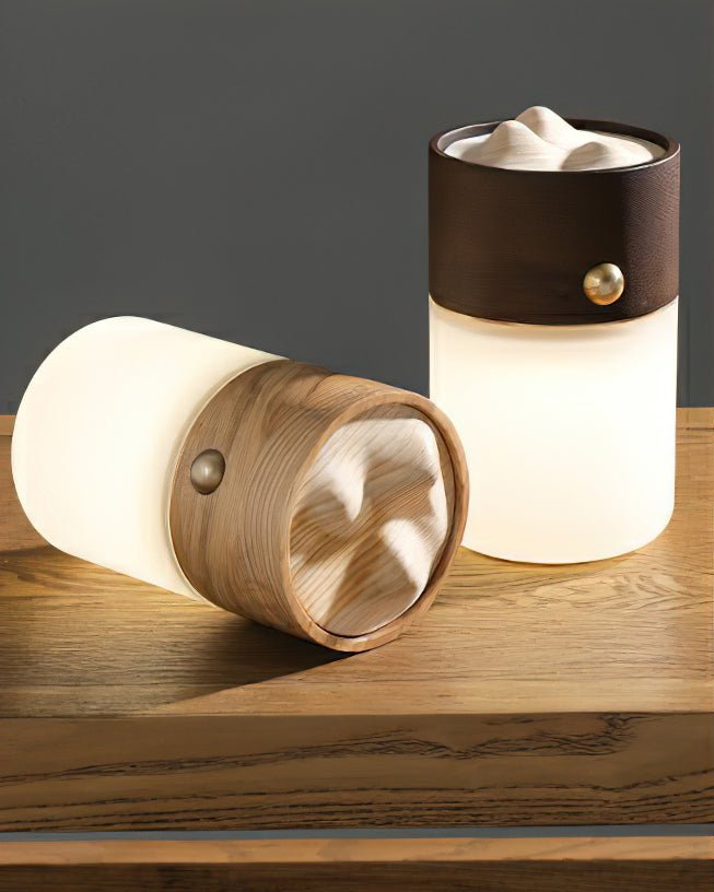 Two lantern table lamps on a wooden table, one lying on its side