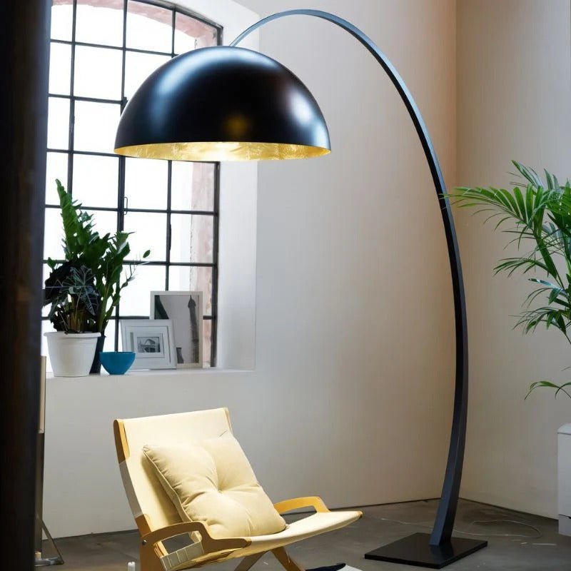 The lit black dome above a reading chair in a corner with plants and a window