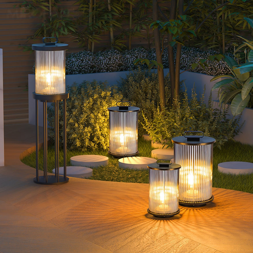 Lanterns lit along a timber deck with pebbles and planting beside them