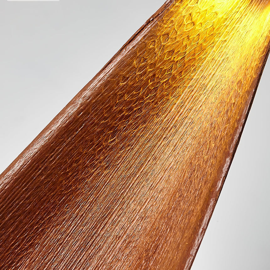 The dried cocoa leaf seen close, its veins glowing amber