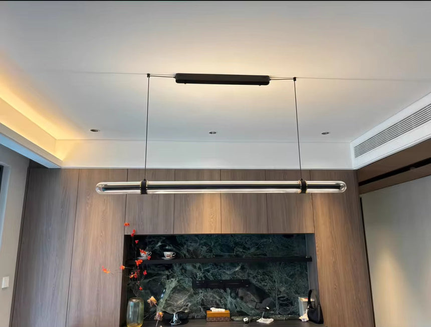 The lit bar hung in a living room above a sideboard with artwork