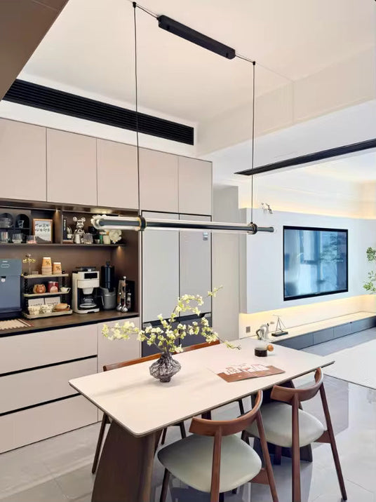 The lit bar hung above a table in an open kitchen with shelving