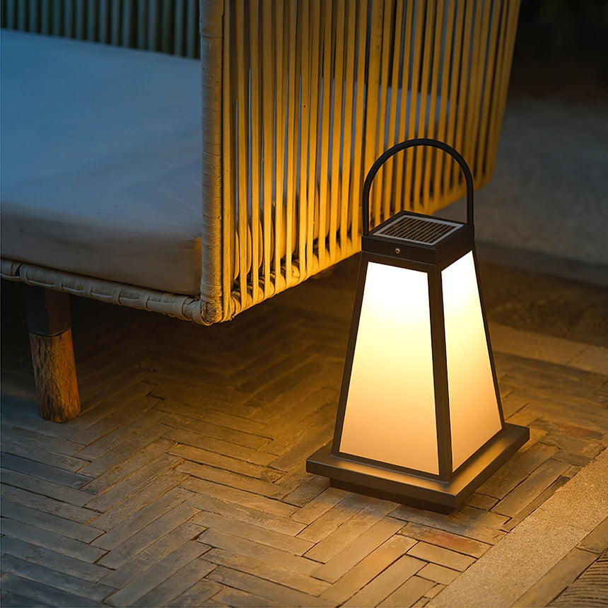 The lantern lit on a paved terrace beside a slatted timber screen