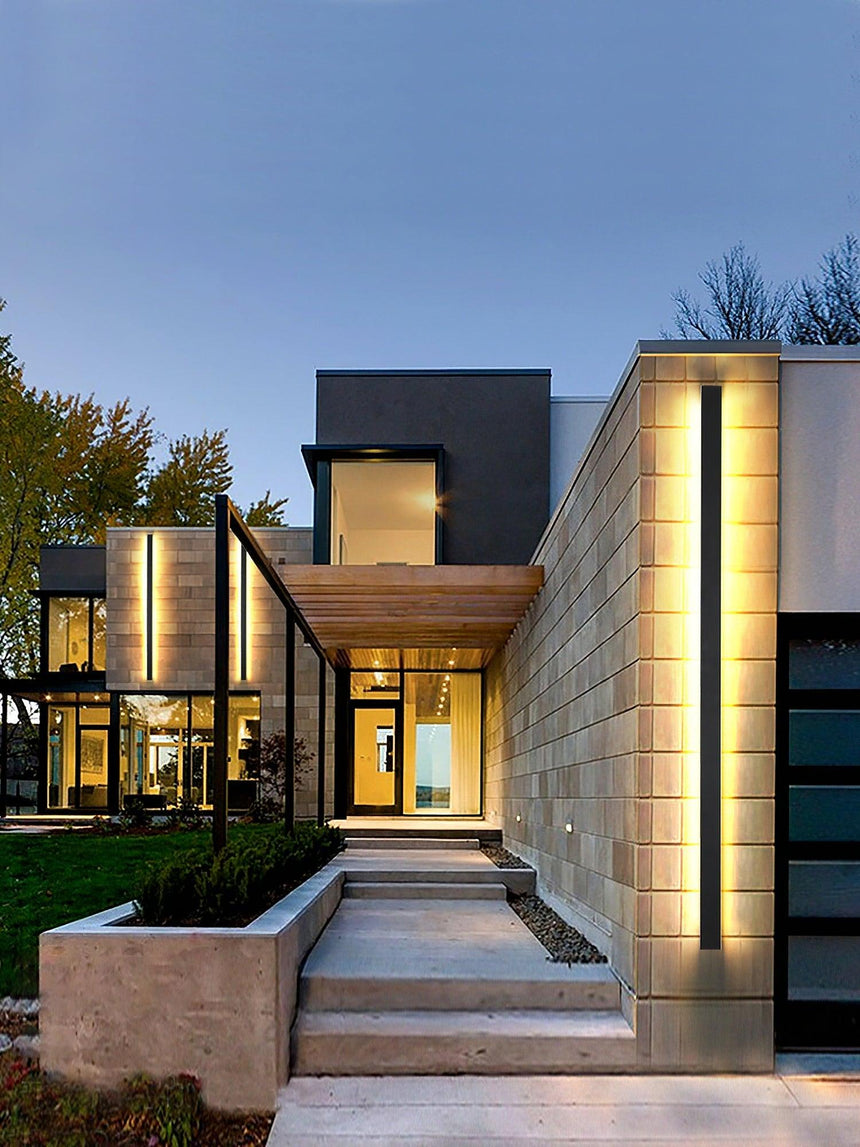 A long strip washing a stone facade beside a front path and a lit doorway