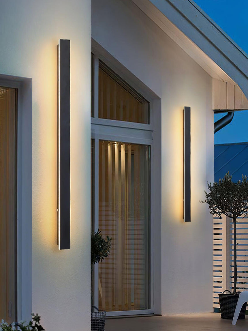 Two strips of different lengths lit on a white gable wall beside tall windows