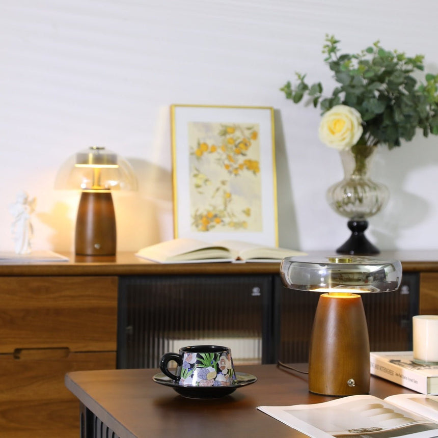 LED table lamp lit on a desk in front of framed botanical prints