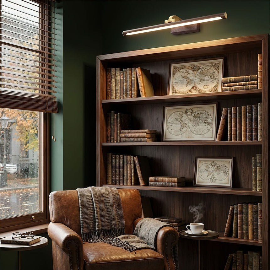 Brass bar lit above a bookcase of old books beside an armchair and a side table