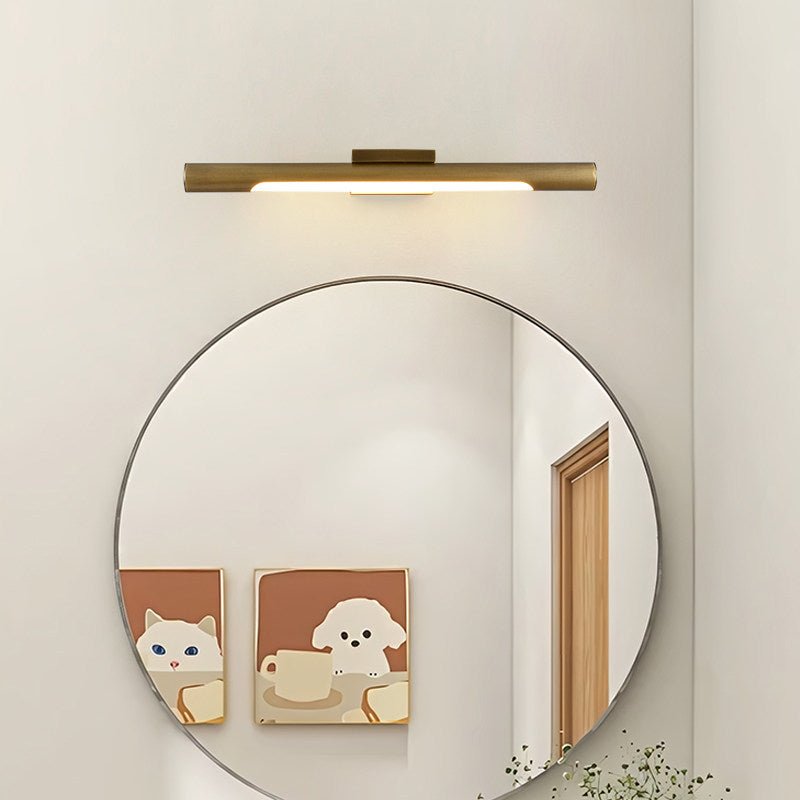 Brass tube lit above a round mirror beside two framed animal prints