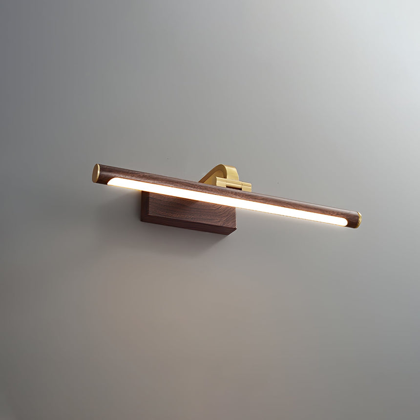 The walnut tone bar seen at an angle, the brass arm behind it against a wall