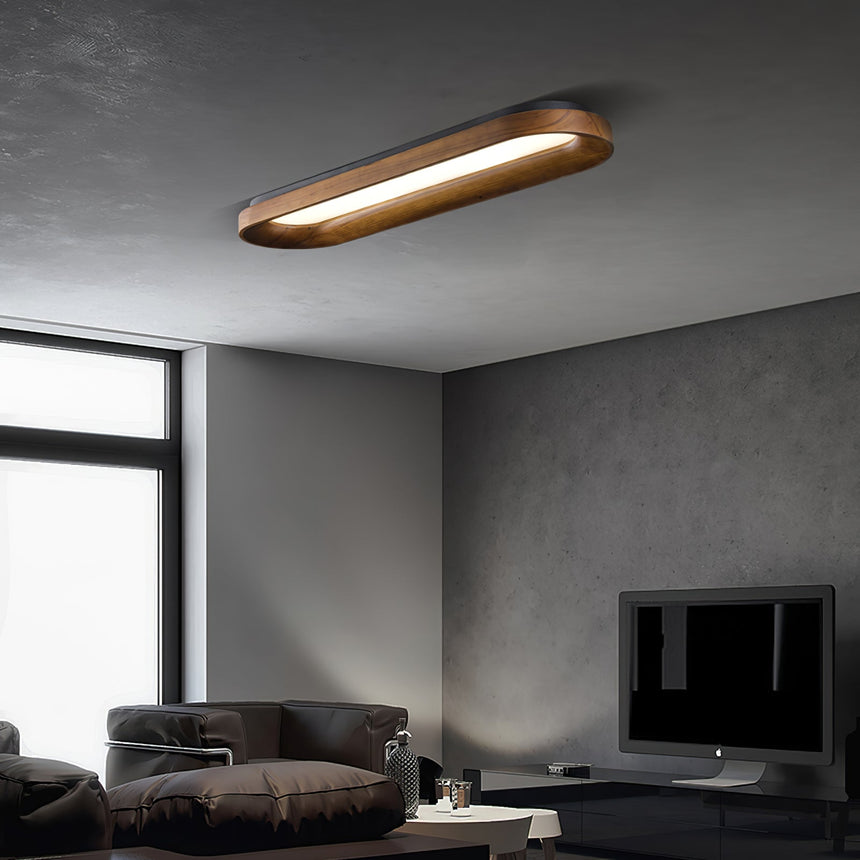 Linear ceiling light lit above a sofa in a gray room with a wall mounted screen