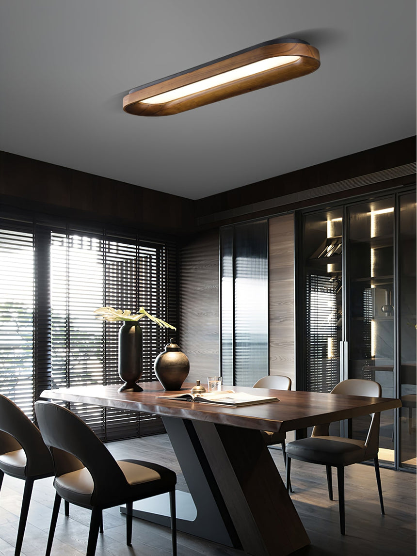 Linear wood frame ceiling light above a dining table with a view outside