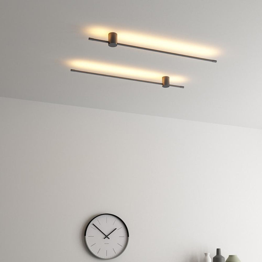 Two rods lit near a ceiling above a round wall clock and a small shelf