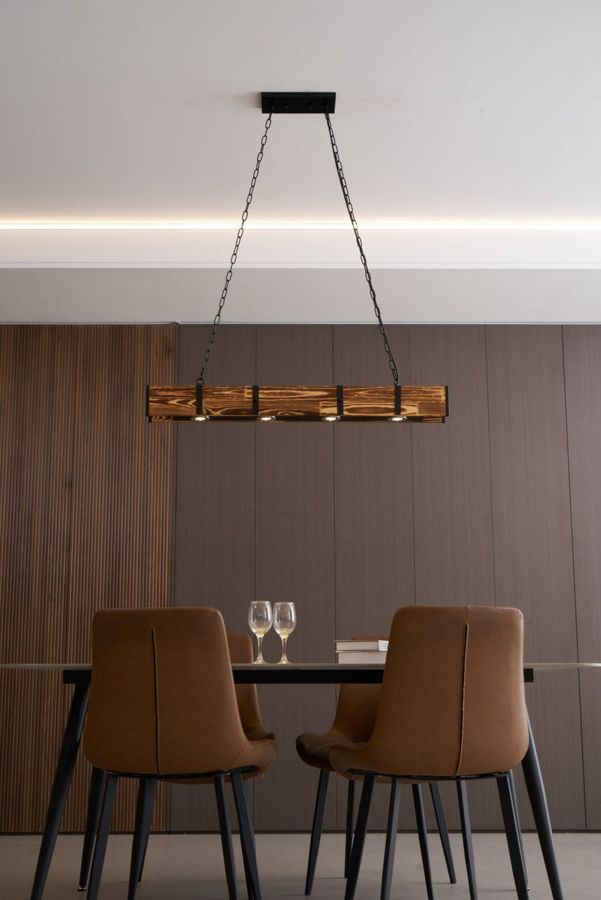 Lit above a table with brown leather chairs in a room with a dark wall