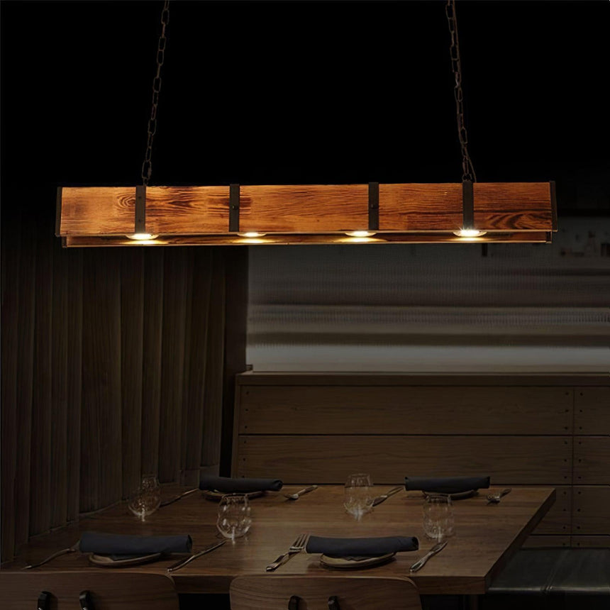 The beam lit over a set table with glasses and napkins in a dark room