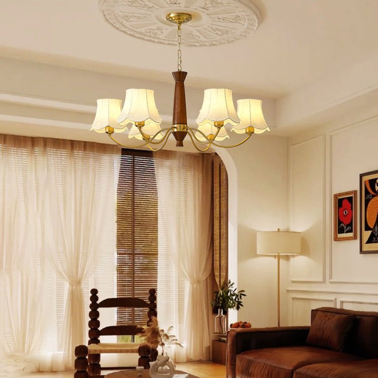 Chandelier lit in a living room above a chair and a wood table