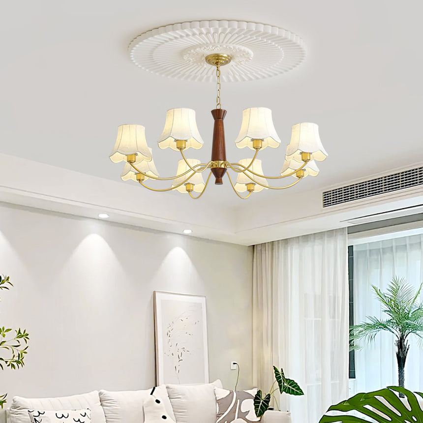 Chandelier lit in a pale living room above a sofa and a plant