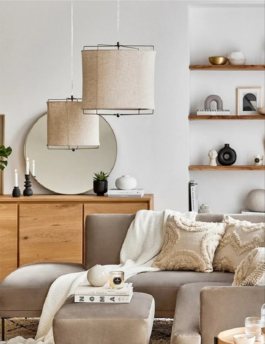 Linen drum pendant light lit in a furnished living room